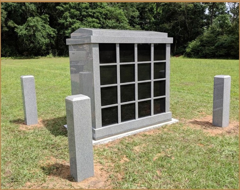 A multi niche columbarium with black granite fronts, standing on a lawn