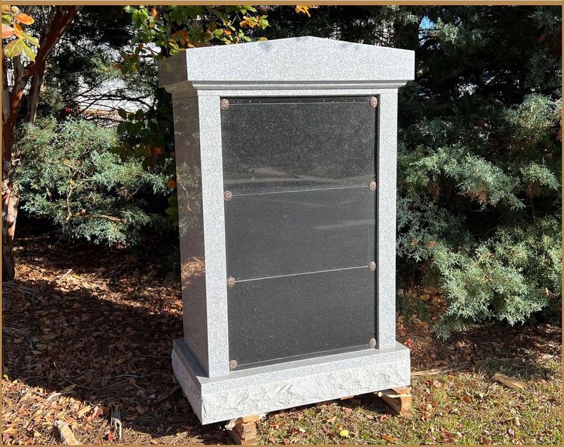 A white granite columbarium with black niche fronts