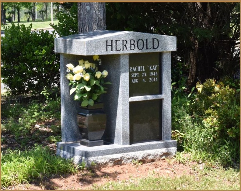 A private granite mausoleum lettered HERBOLD, with flowers at the front