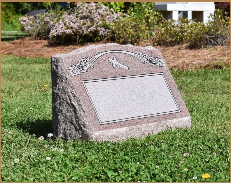 A rustic pink granite boulder with a polished inscription panel