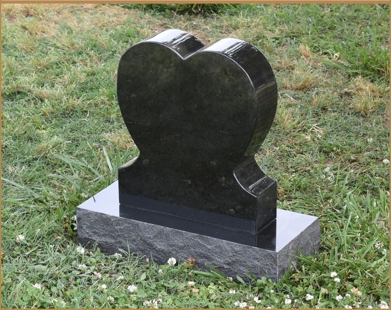 A polished black granite heart monument on a grey base