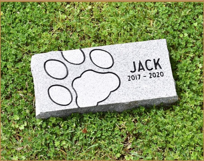 A granite pet marker carved with a paw print and the name JACK